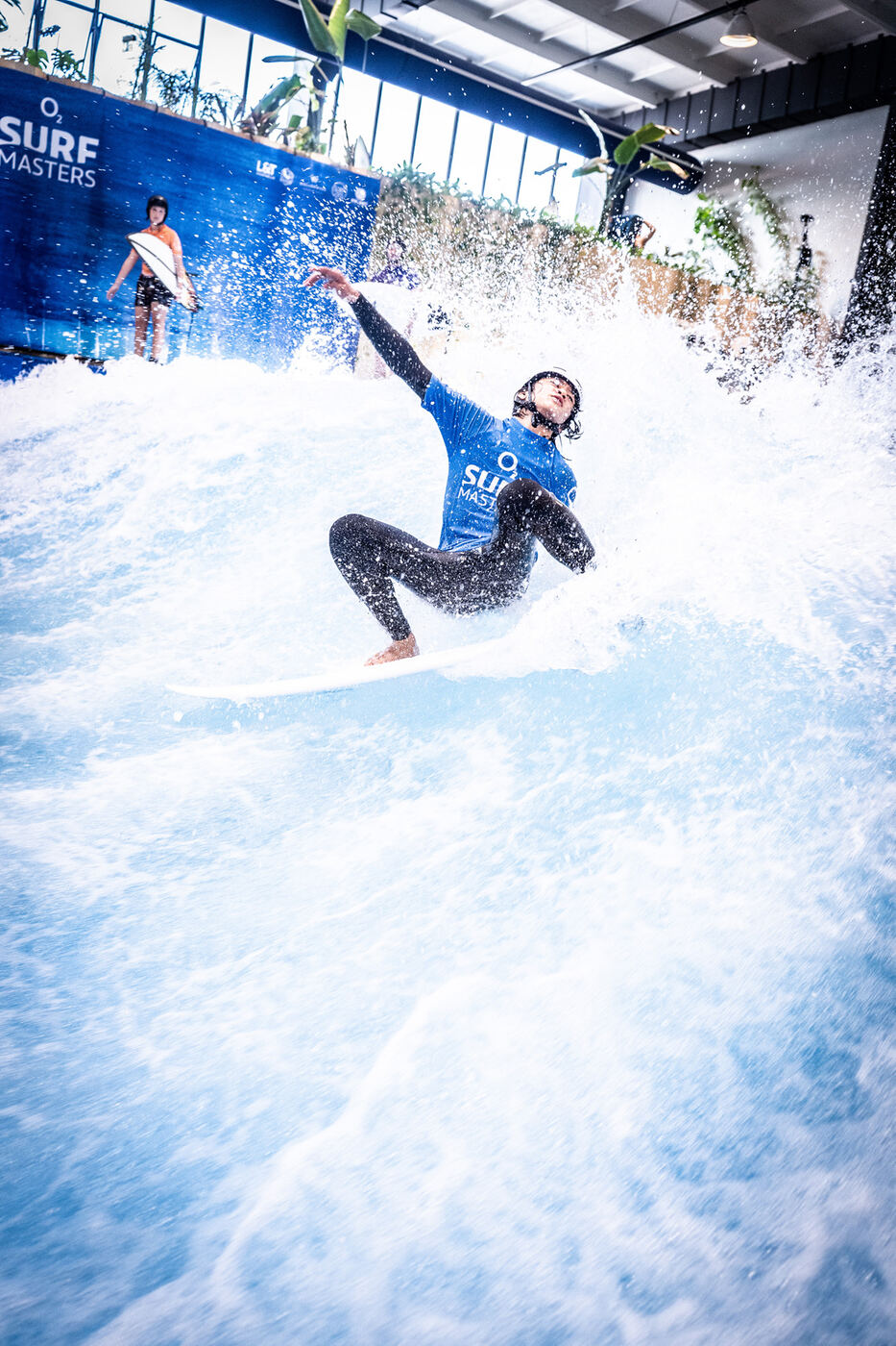 Surfer schaut direkt in die Kamera, Board in der Luft