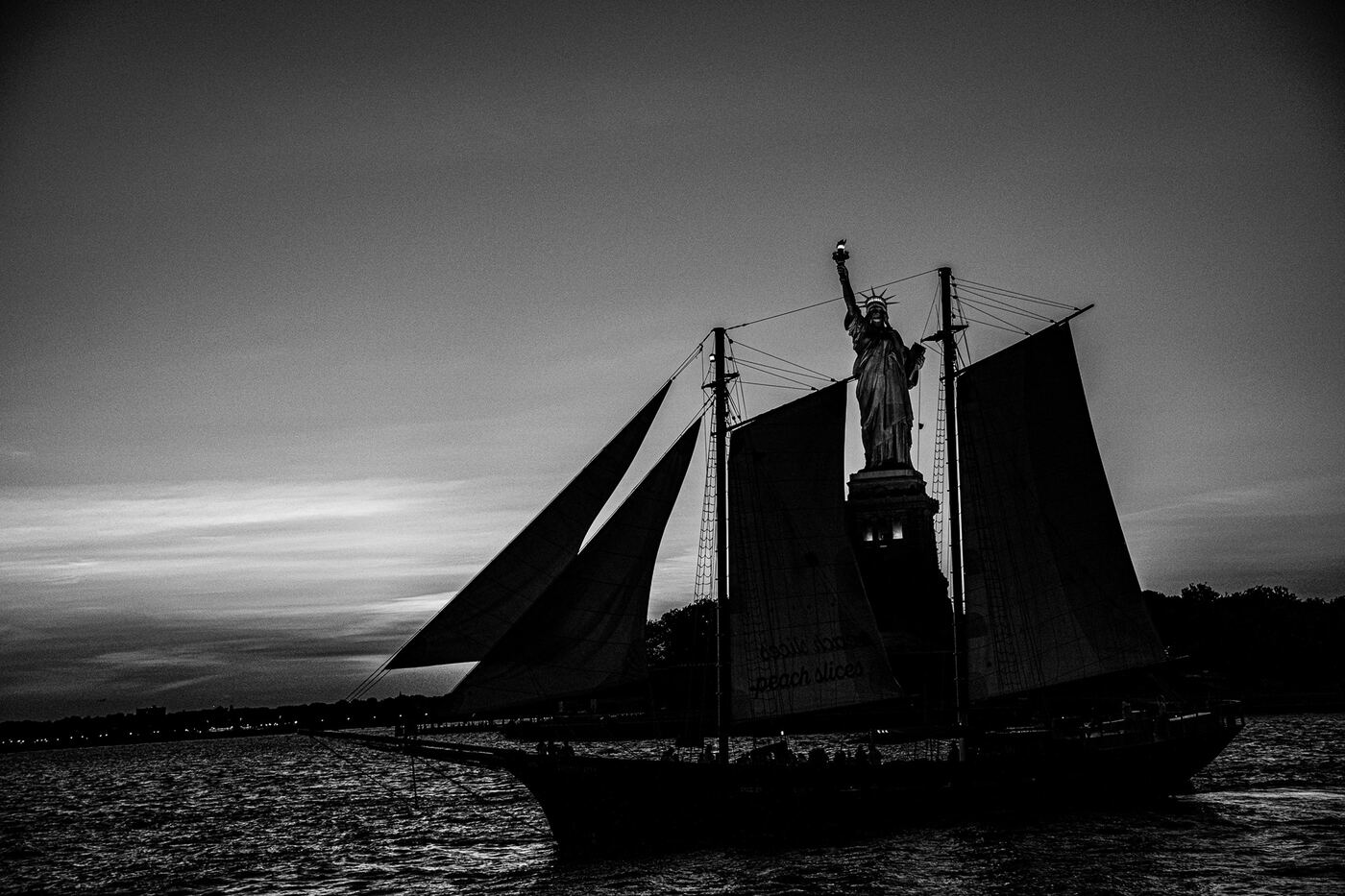 Silhouette eines Segelschiffs vor der Freiheitsstatue